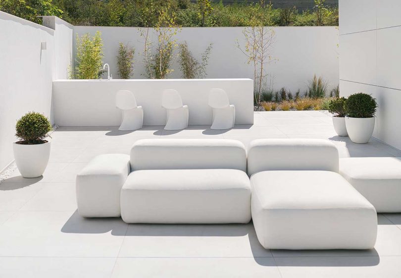 exterior minimalista de una casa blanca moderna con asientos al aire libre