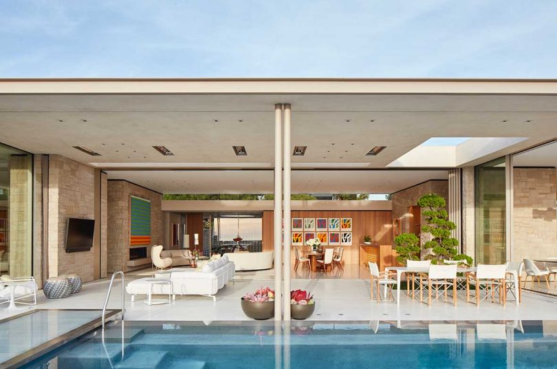 vista exterior mirando hacia el interior de una casa moderna frente a la piscina
