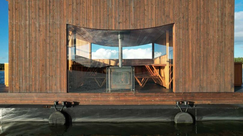 vista lateral de una moderna sauna flotante de madera en el agua