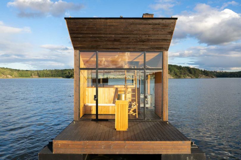vista final de una moderna sauna flotante de madera en el agua