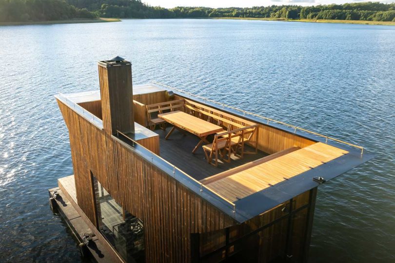 en ángulo sobre la vista de una moderna sauna flotante de madera en el agua
