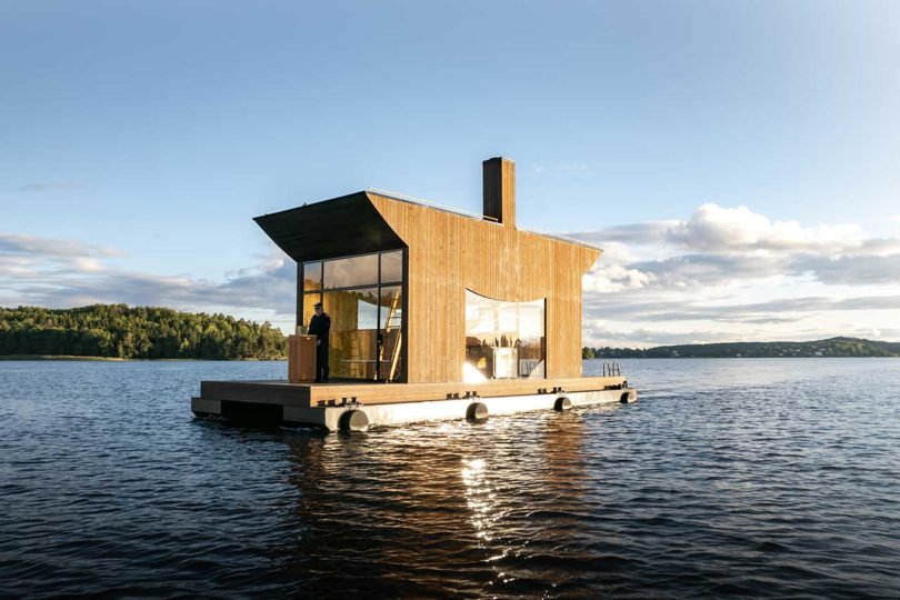 vista oblicua de una moderna sauna flotante de madera en el agua