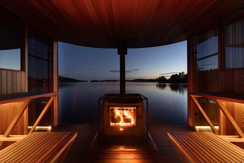 vista crepuscular de una moderna sauna flotante de madera en el agua