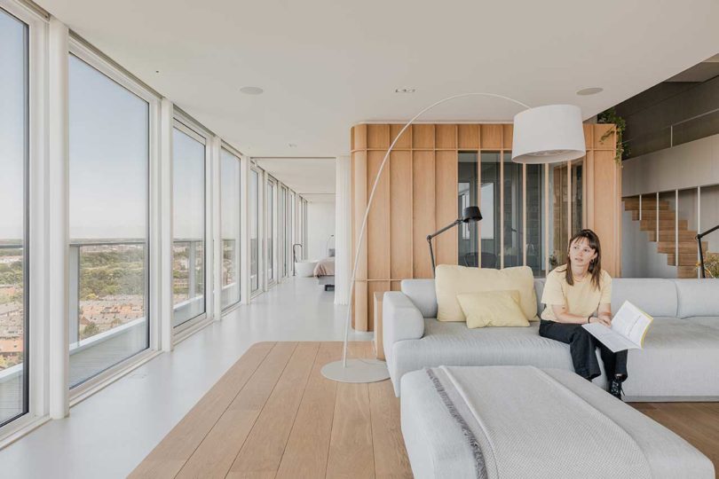 vista interior de la esquina de un moderno apartamento tipo loft con una plataforma de sofá de madera elevada
